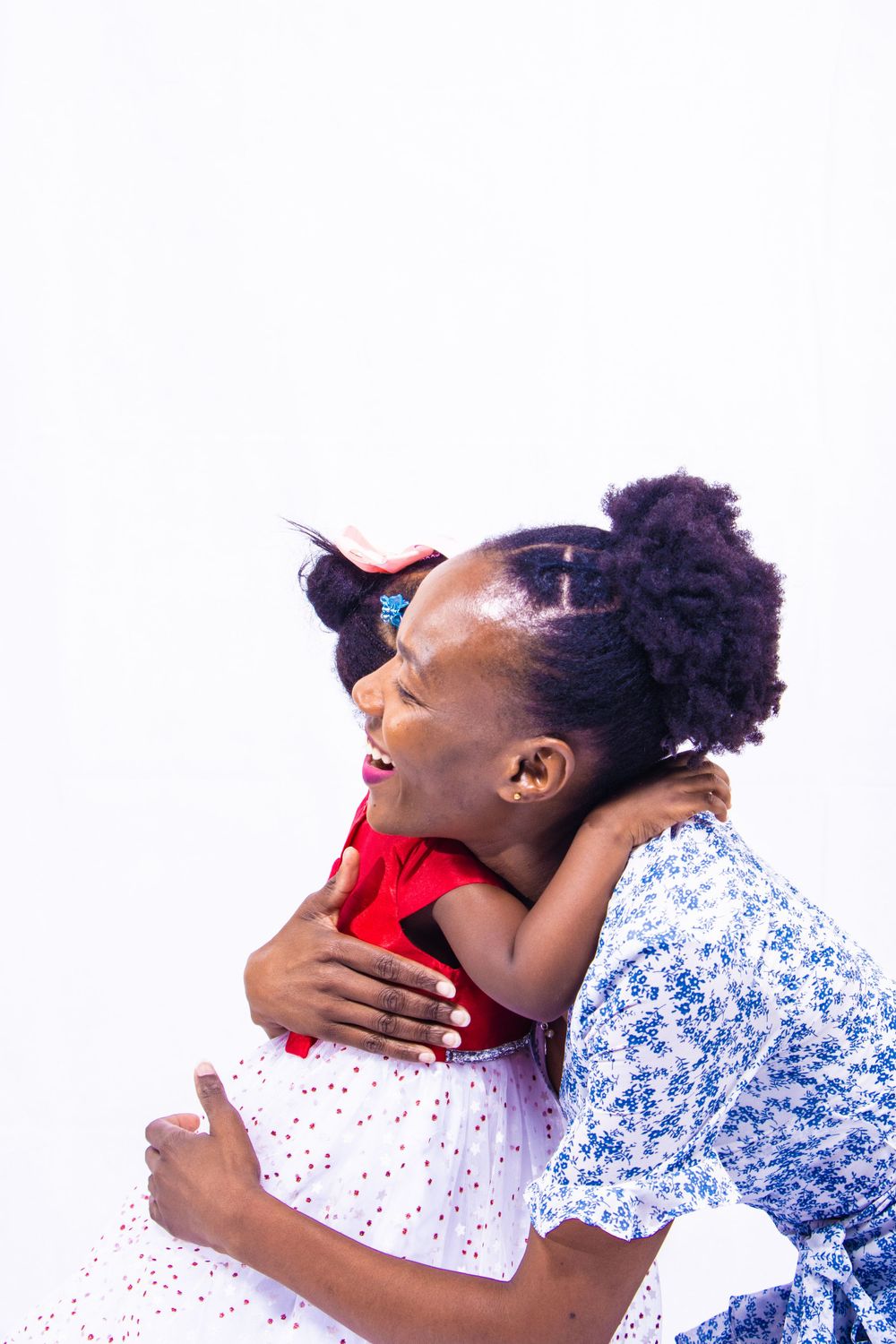 An emotional embrace captured against a white background with floral and red clothing.