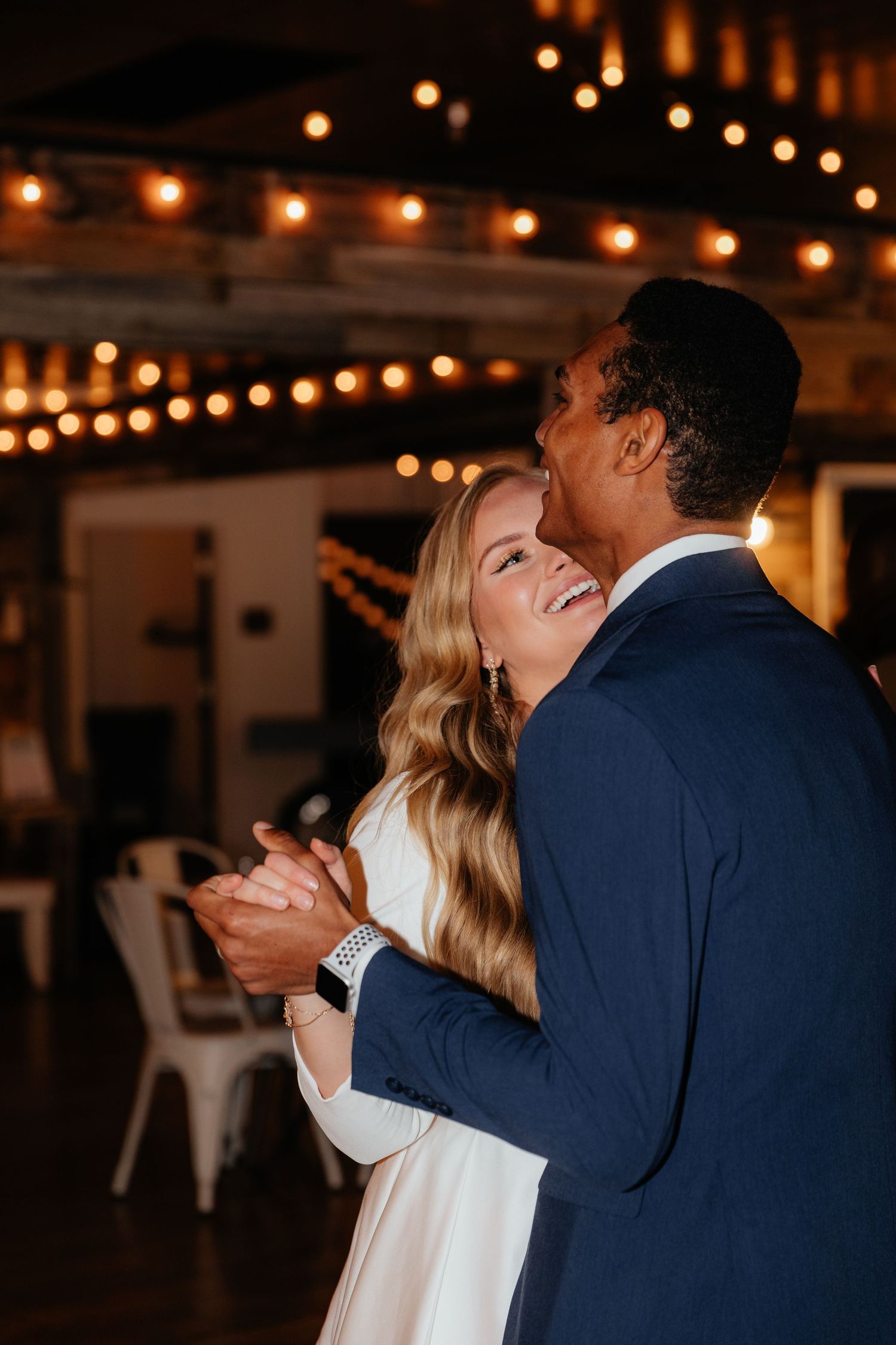 Bride laughing up at groom during first dance