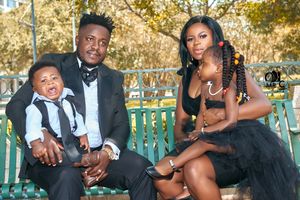 Formal family portrait on a park bench during autumn with elegant black and brown attire.