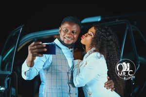 Candid moment between couple in formal wear by car at night.