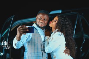 Romantic nighttime portrait of couple in formal attire by car.