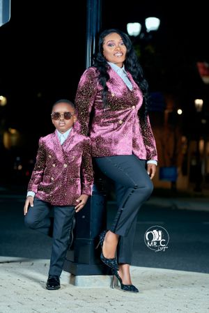 Matching pink sequin outfits pose against nighttime urban backdrop.