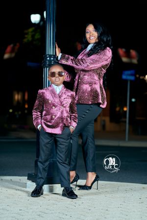 Stylish matching pink velvet outfits paired with black pants in nighttime urban setting.