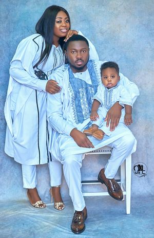 Family portrait in coordinated white and blue traditional attire.
