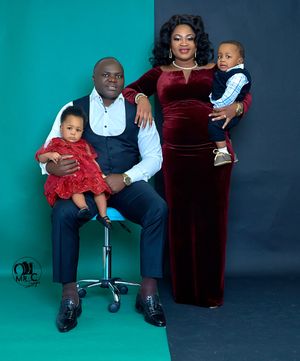 Family portrait in velvet attire against blue and teal backdrop.