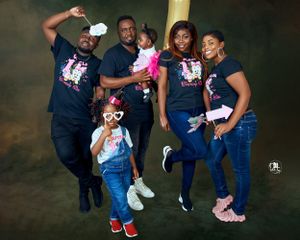 Energetic family photo with group jumping and posing in coordinated black t-shirts.