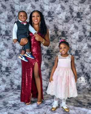 Studio portrait with red sequin gown and white lace dress against textured gray background.