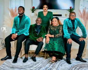 Formal group photo with five people wearing coordinated emerald green and black attire.