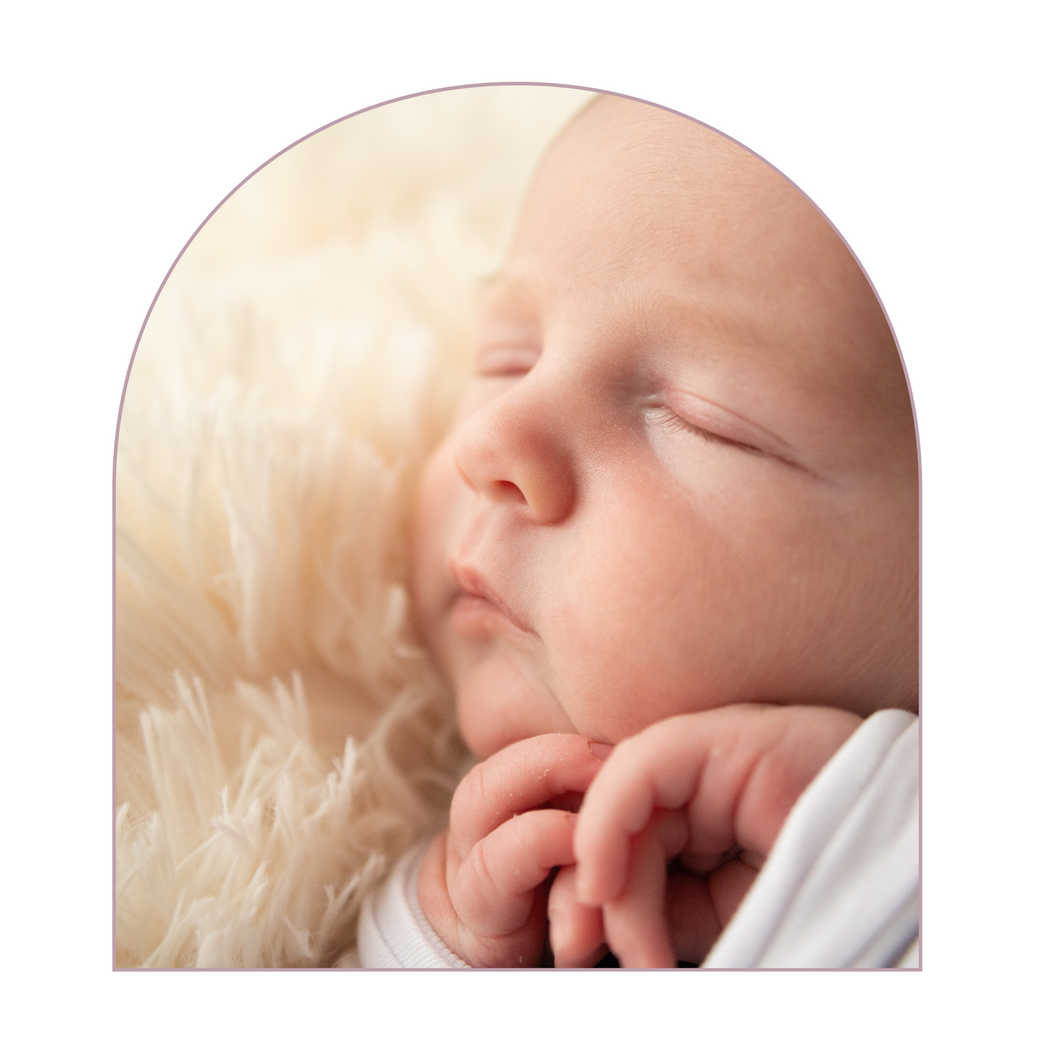 A peaceful sleeping baby nestled in soft white and cream textured fabrics.