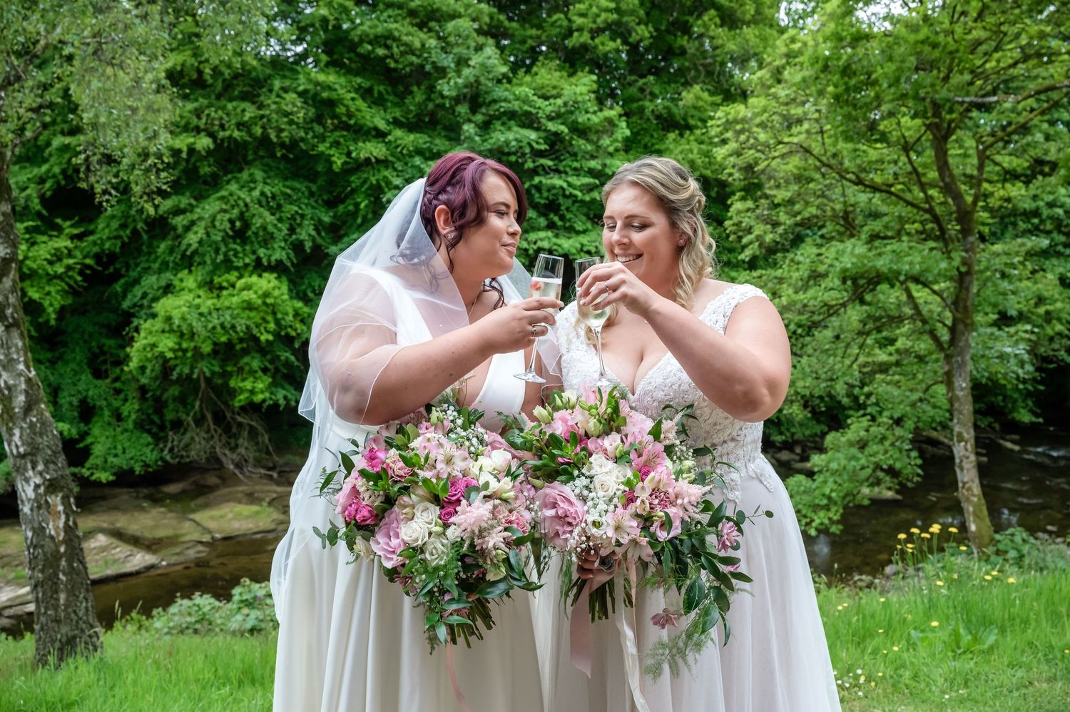 Two brides enjoying a drink after their wedding ceremony at the Hidden River Barn