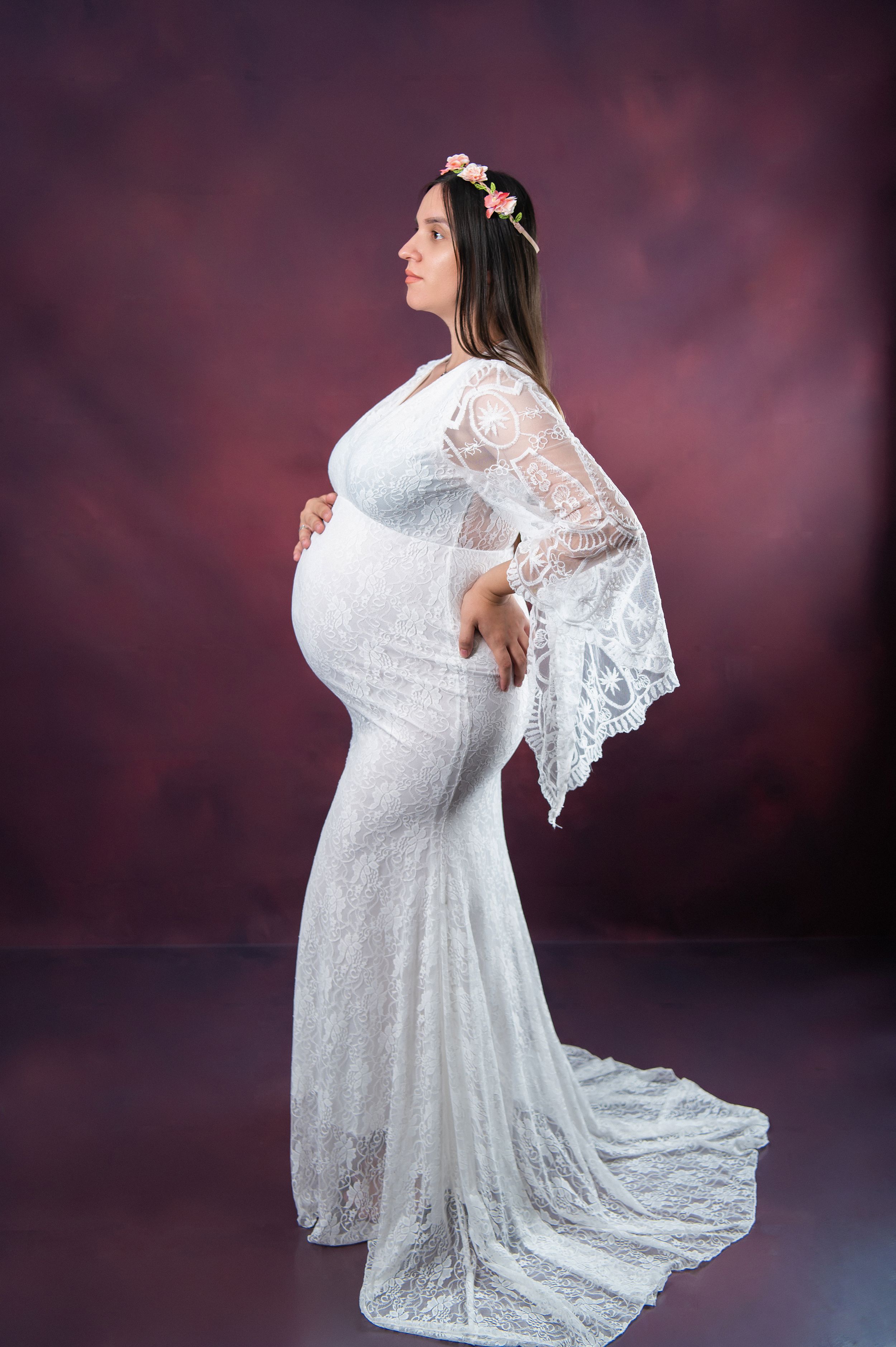 Full-length maternity photo showing flowing lace dress with dramatic train.