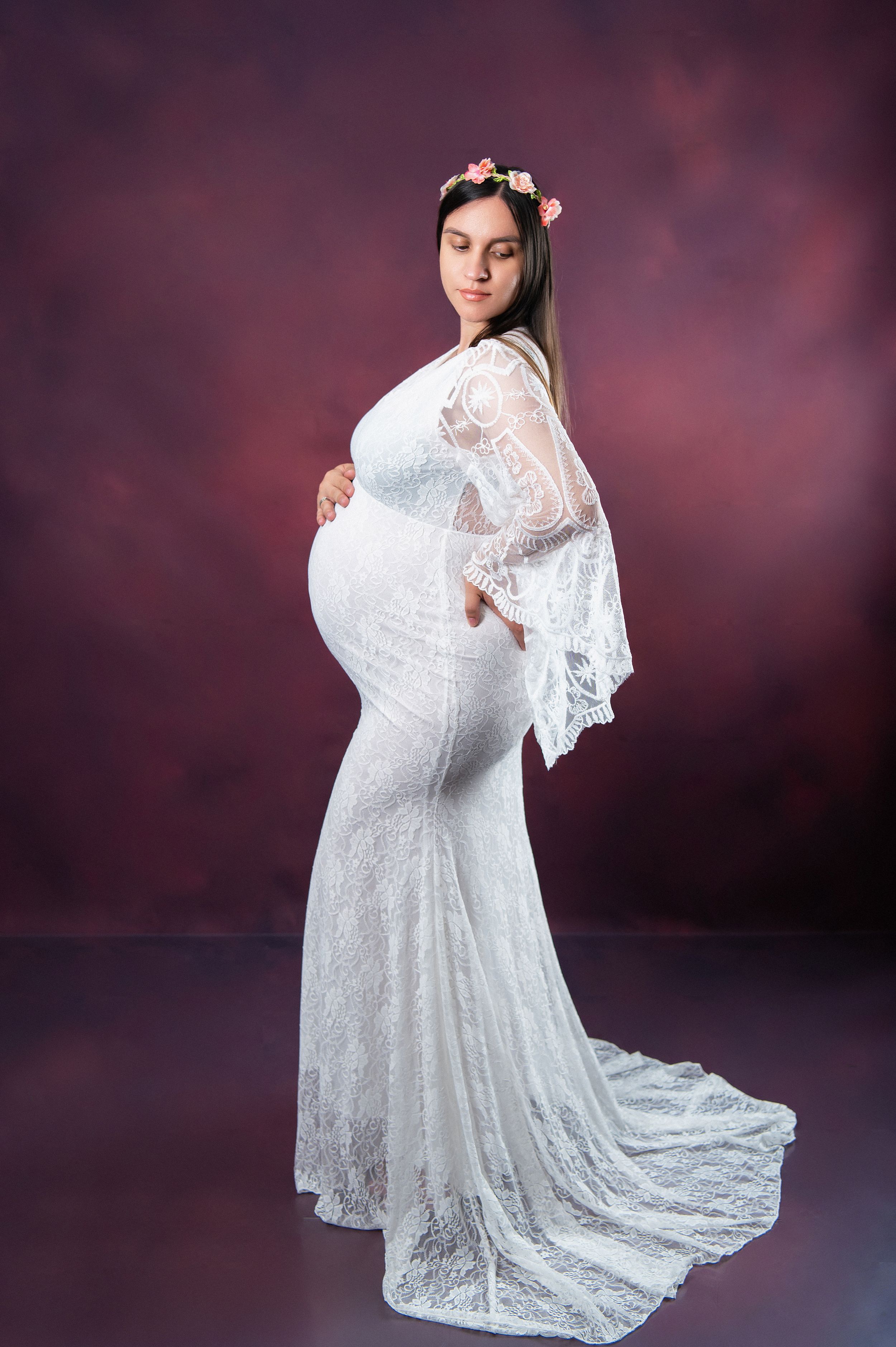 Graceful maternity pose showing off lace dress details and flowing train.