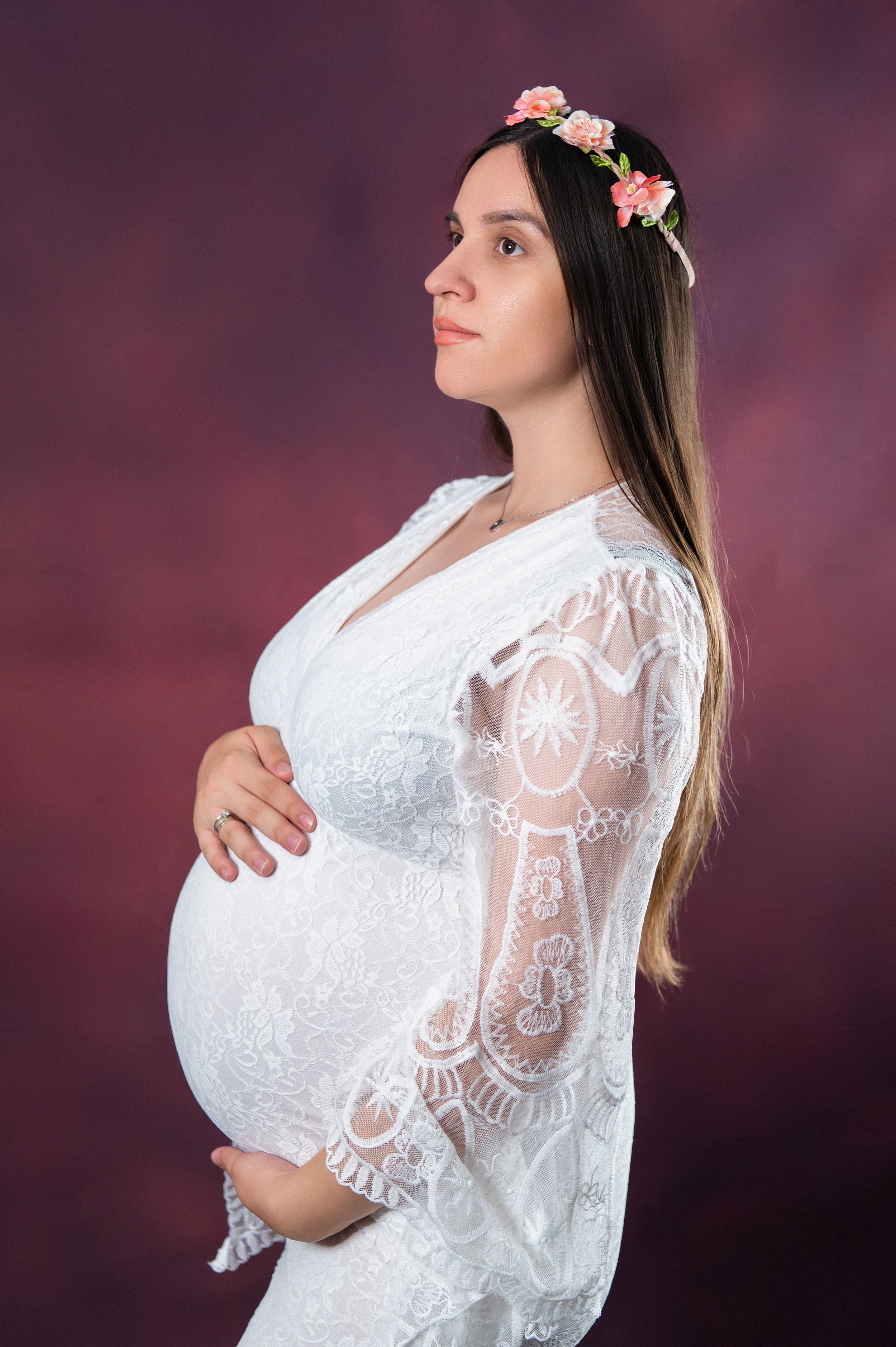 Ethereal maternity portrait with floral crown and white lace bell sleeve dress.