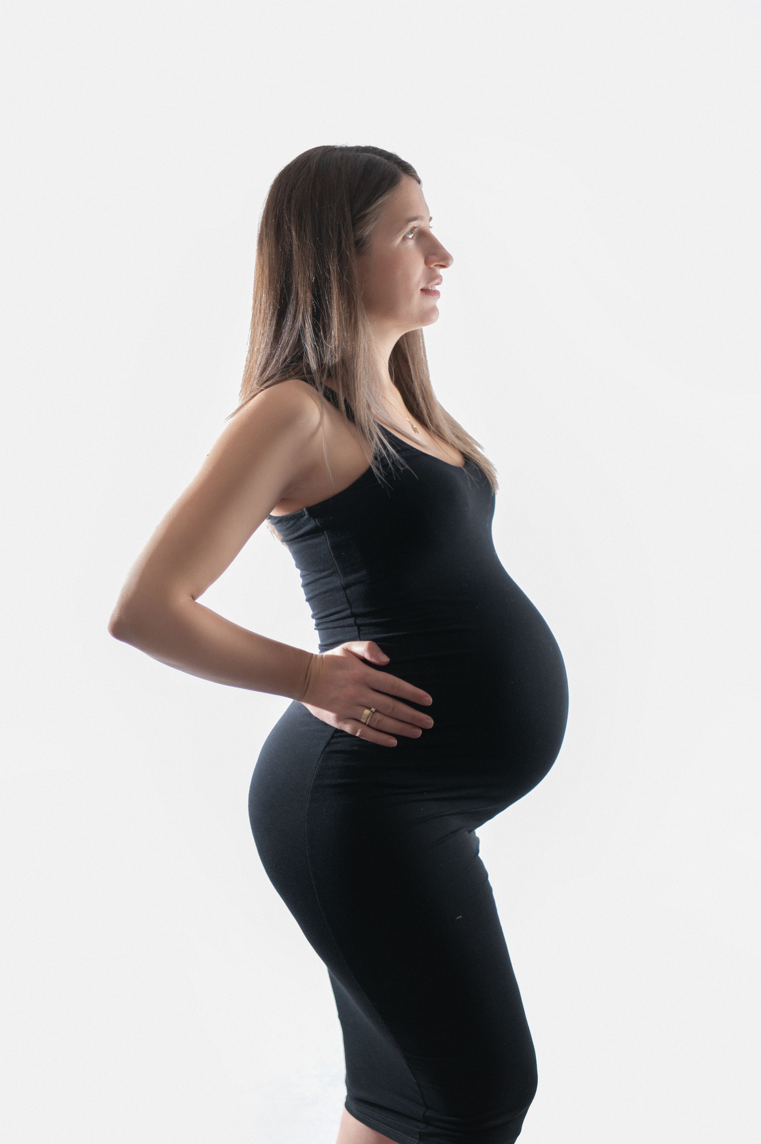 Black and white maternity photos showing pregnant woman in profile against light background.