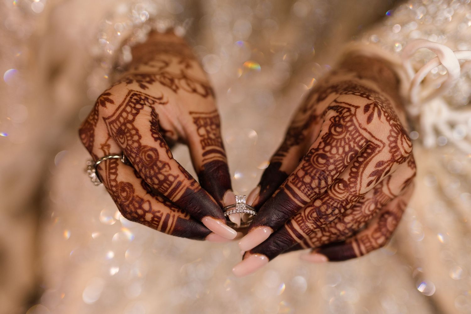 Elegantly placed bridal mehendi while shes holding a bridal ring