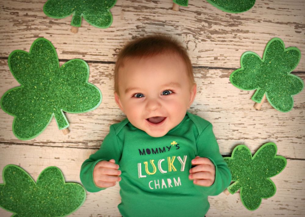 St Patrick's Day themed photo with green shamrock decorations on wooden background.