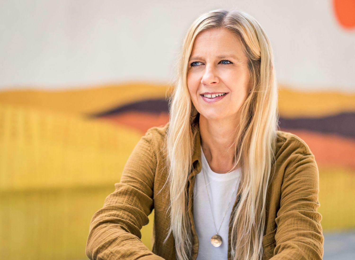 Professional portrait against abstract desert mural background.