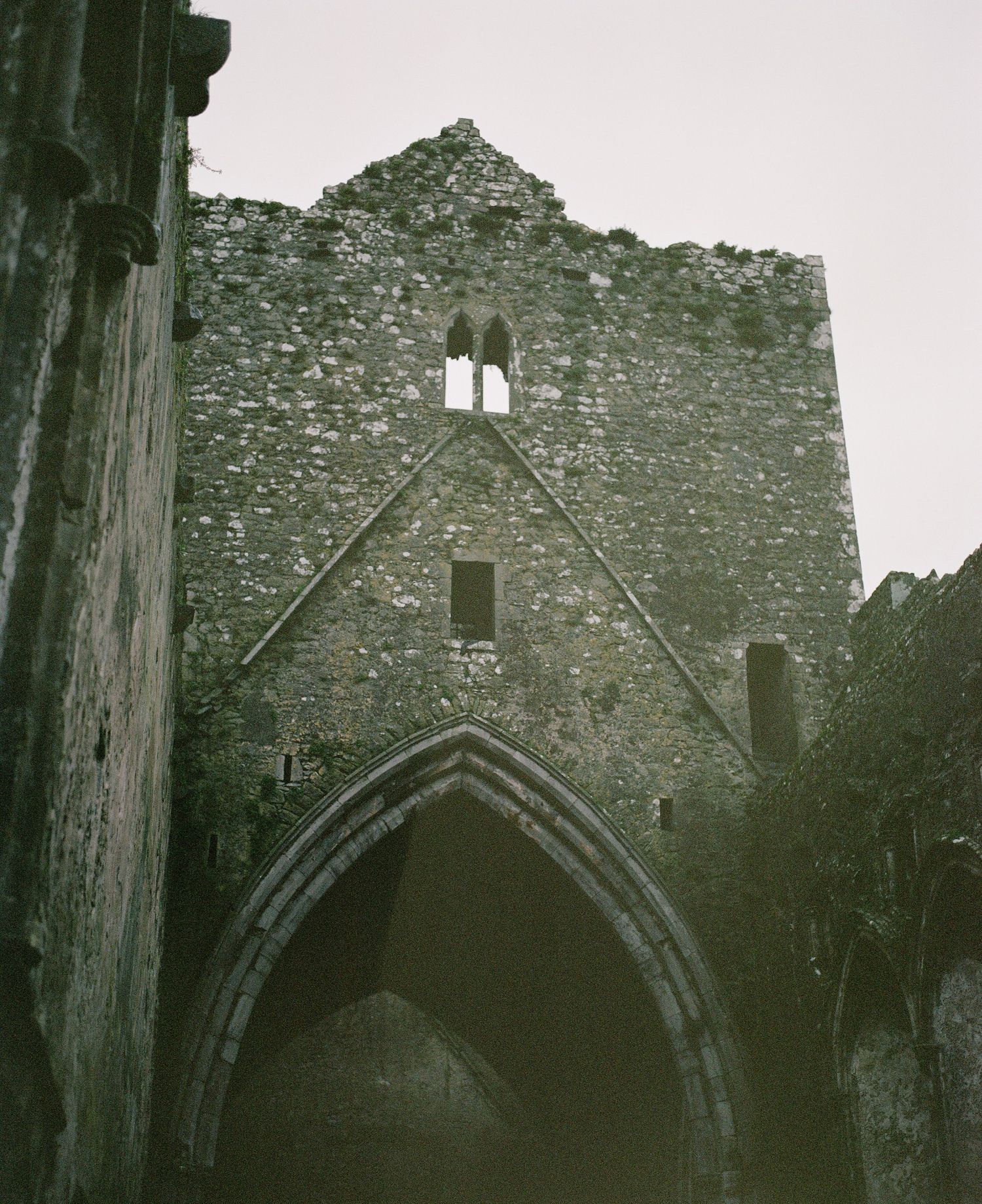 Towering Gothic archway entrance of an old stone church or castle ruin.