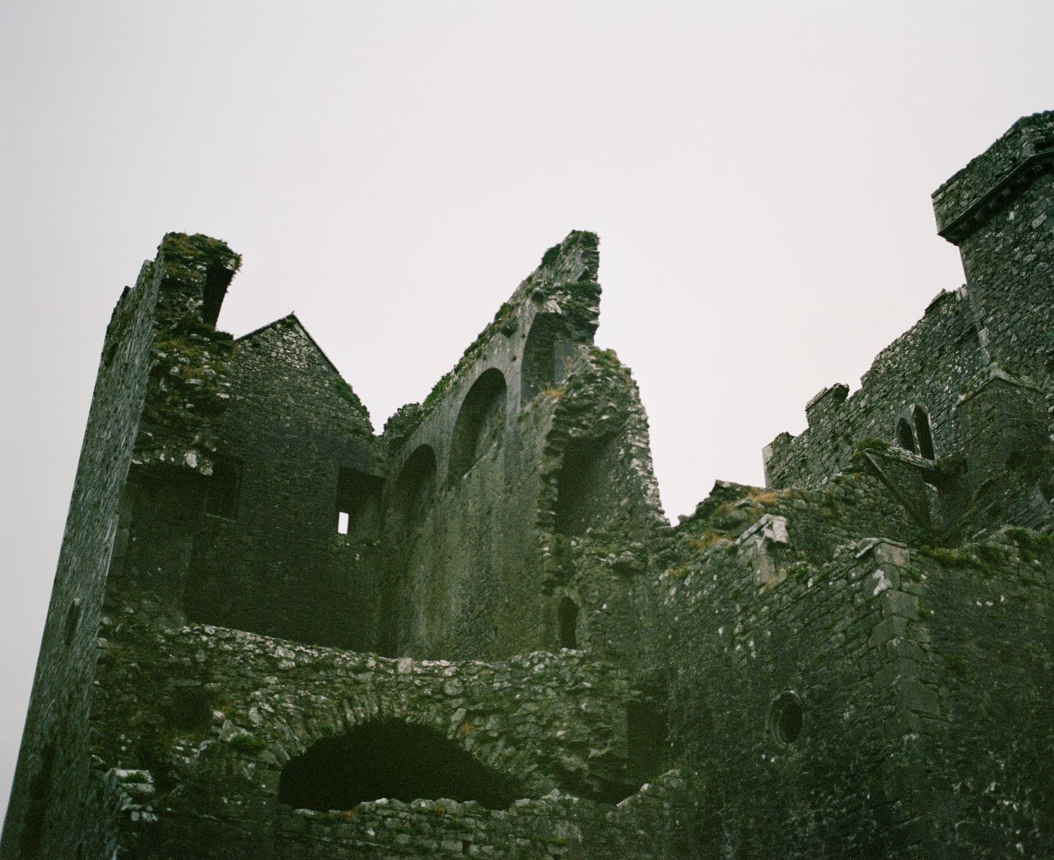 Ancient stone ruins of a Gothic church or cathedral against an overcast sky.
