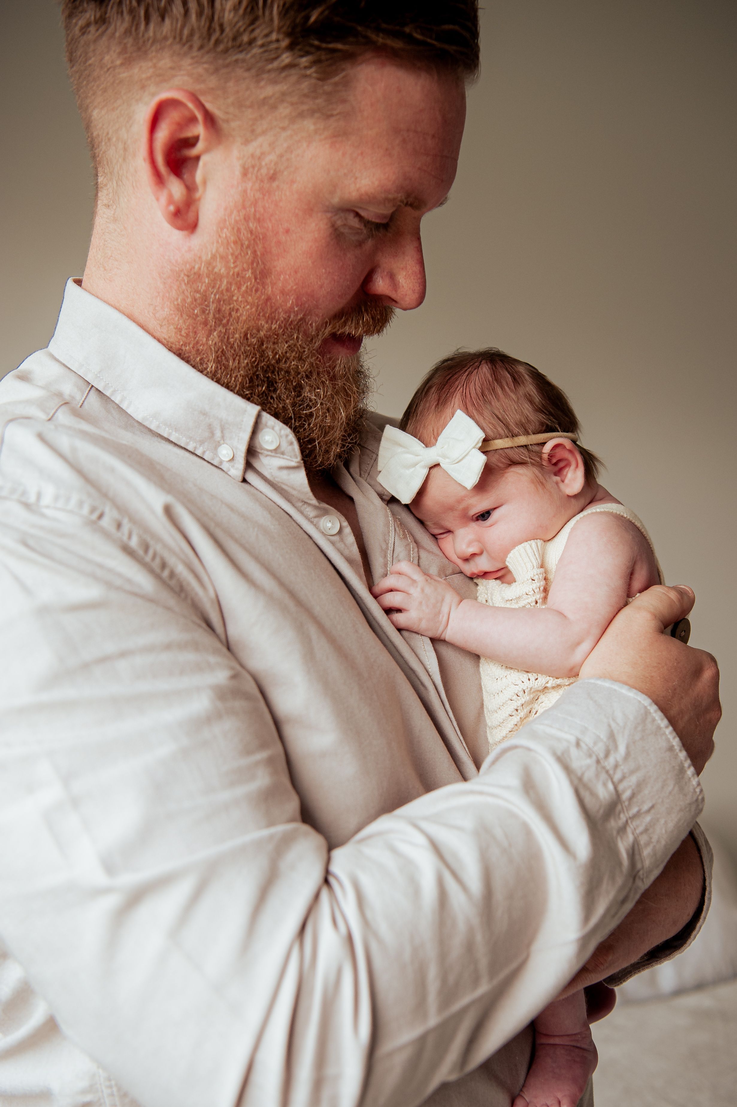 Tender moment between parent and infant wearing white bow headband.
Altona Family Photographer Melbourne