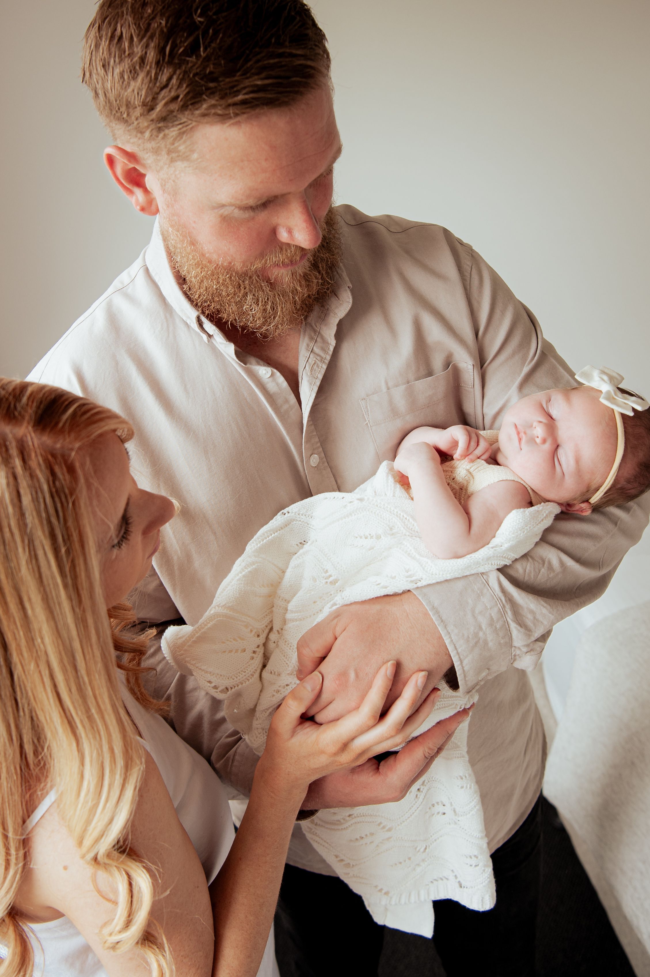 Parents sharing intimate moment while holding their newborn wrapped in white.
Altona Family Photographer Melbourne