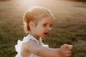 A small child in white clothing explores a grassy field at golden hour.
Altona Family Photographer Melbourne
