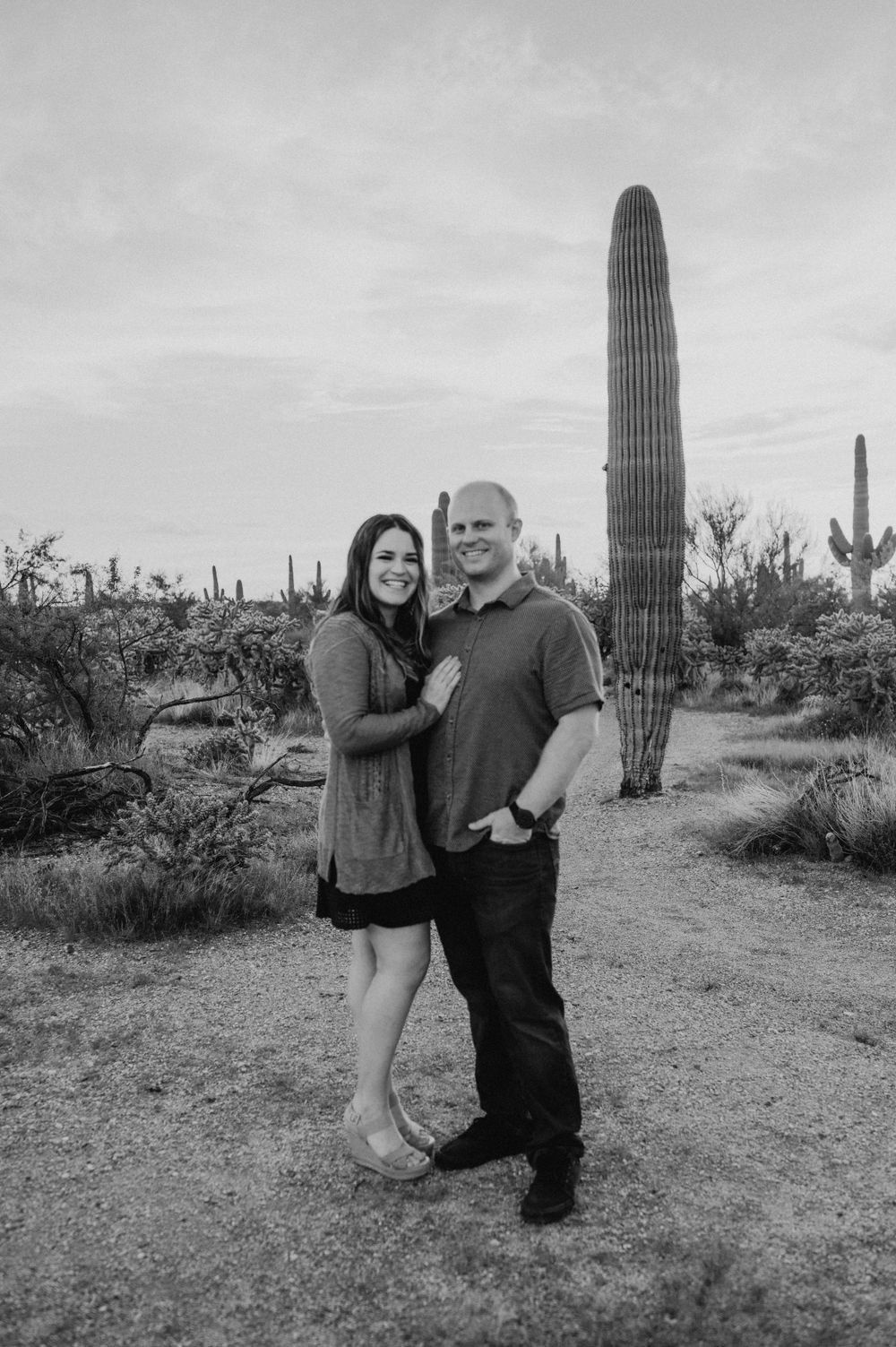 Black and white desert portrait session with saguaro cacti in the background.