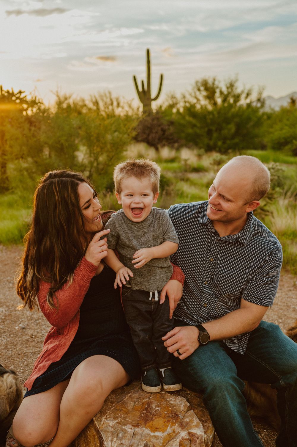 A joyful family moment captured in the desert with saguaro cacti at sunset.