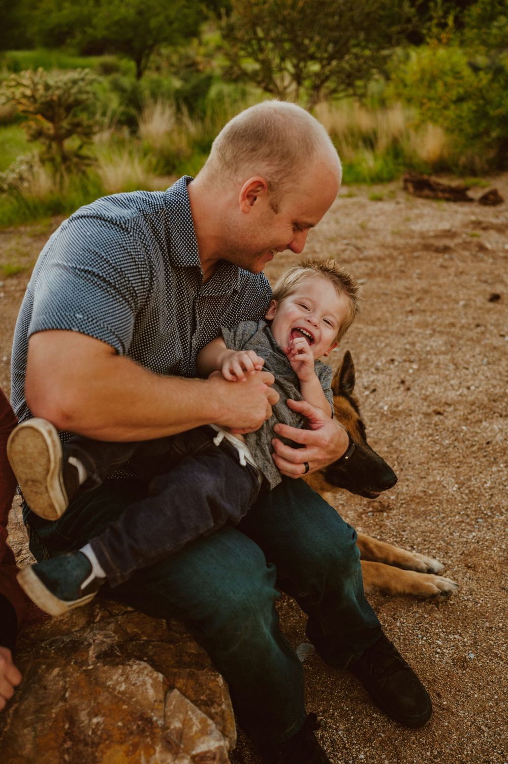 Candid playful moments shared on desert rocks during golden hour.