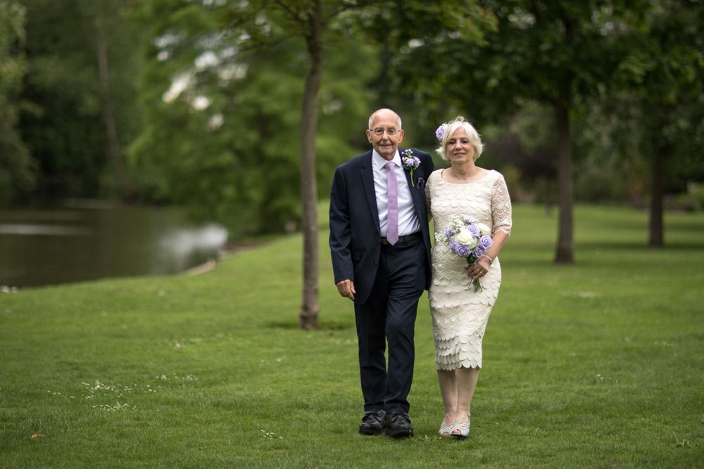 eloped couple walking by the lake at intimate wedding