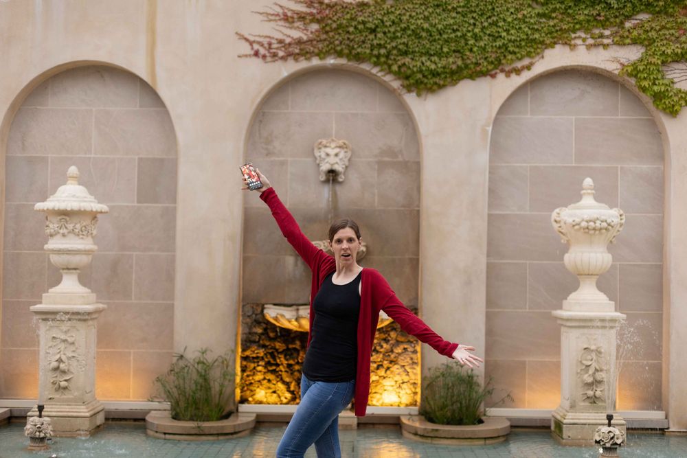 A joyful pose in front of illuminated stone archways and decorative urns.
