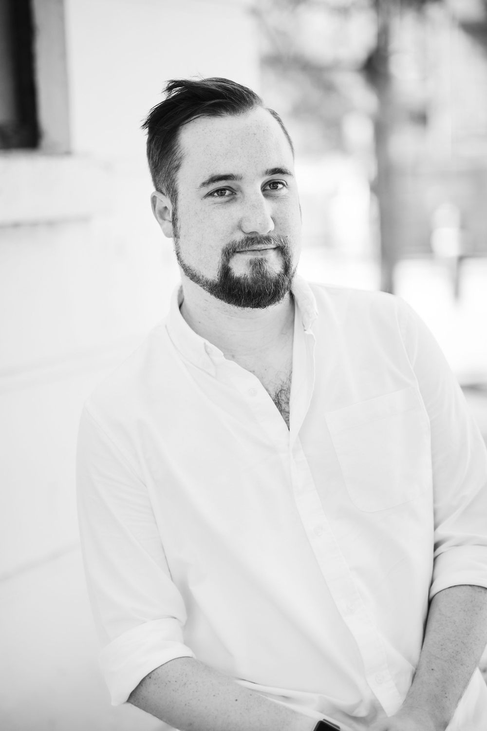 Black and white portrait of person in white shirt against light background.
