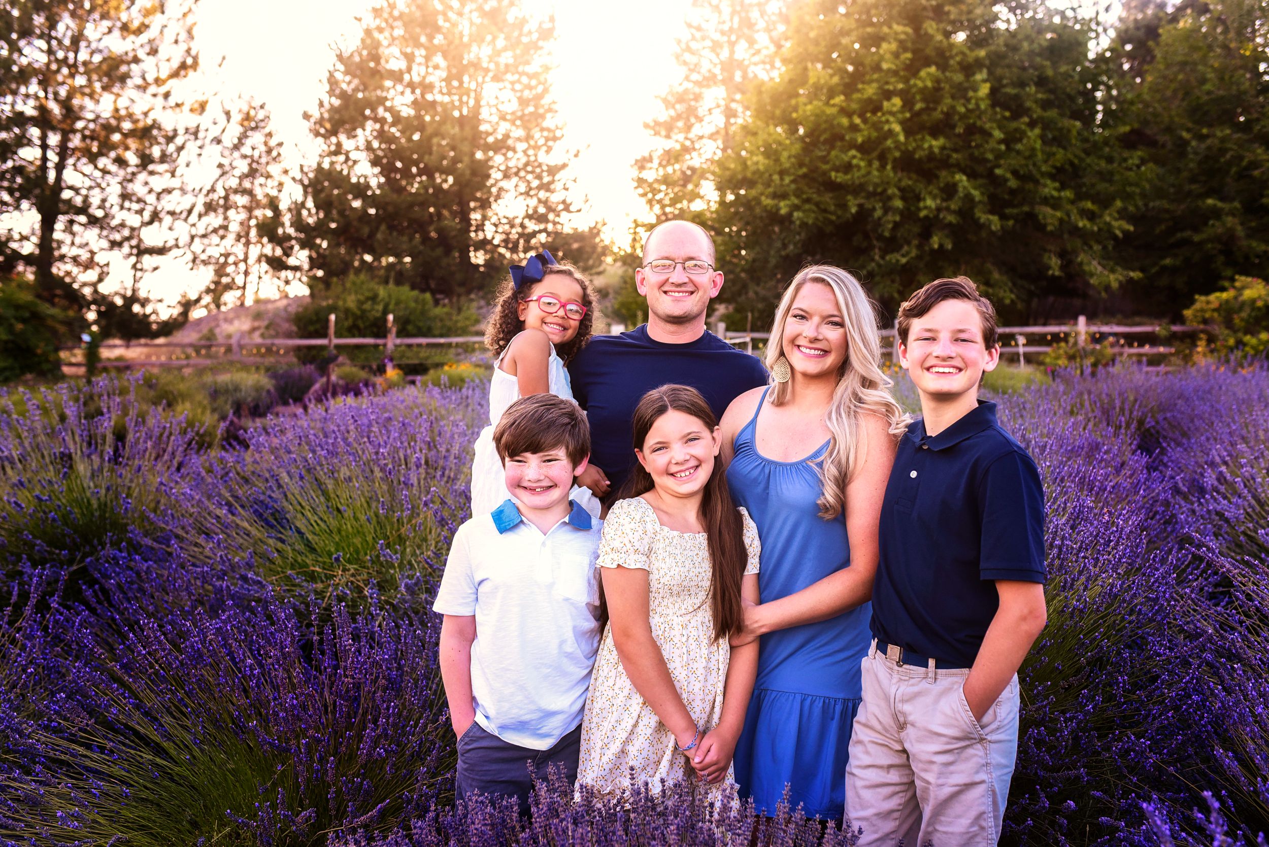 Candid family photo surrounded by rows of flowering lavender at golden hour.