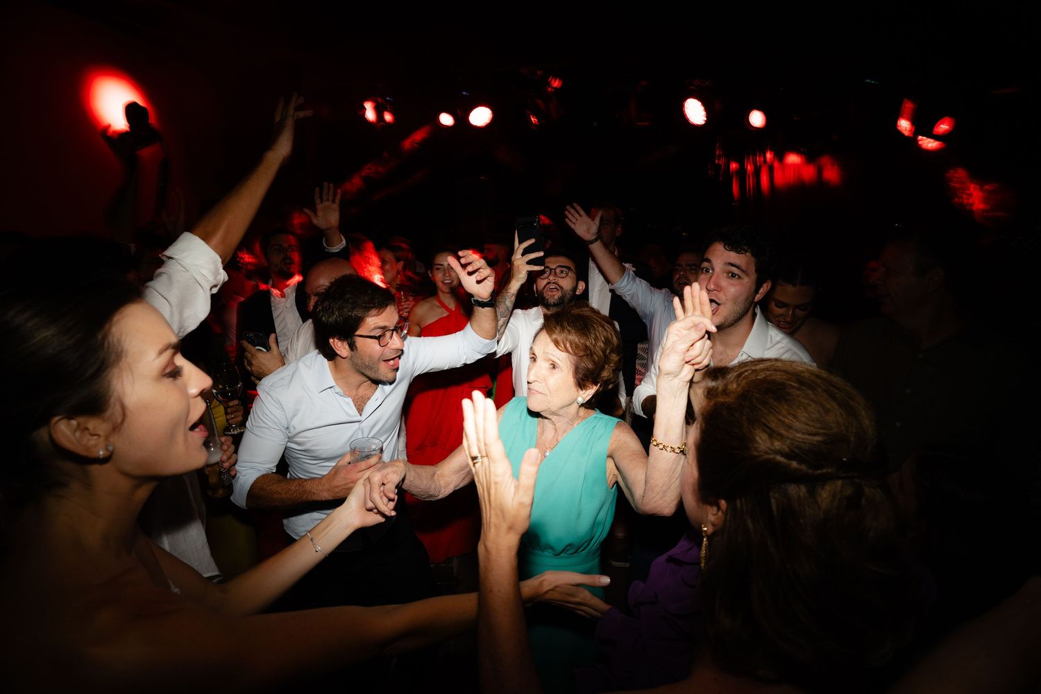 Lively dance party scene with people celebrating under dramatic lighting effects.