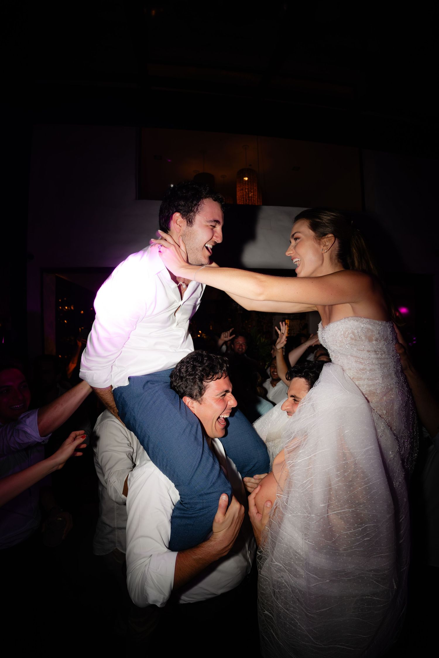 Dynamic dance moves captured at a wedding reception with dramatic lighting effects.