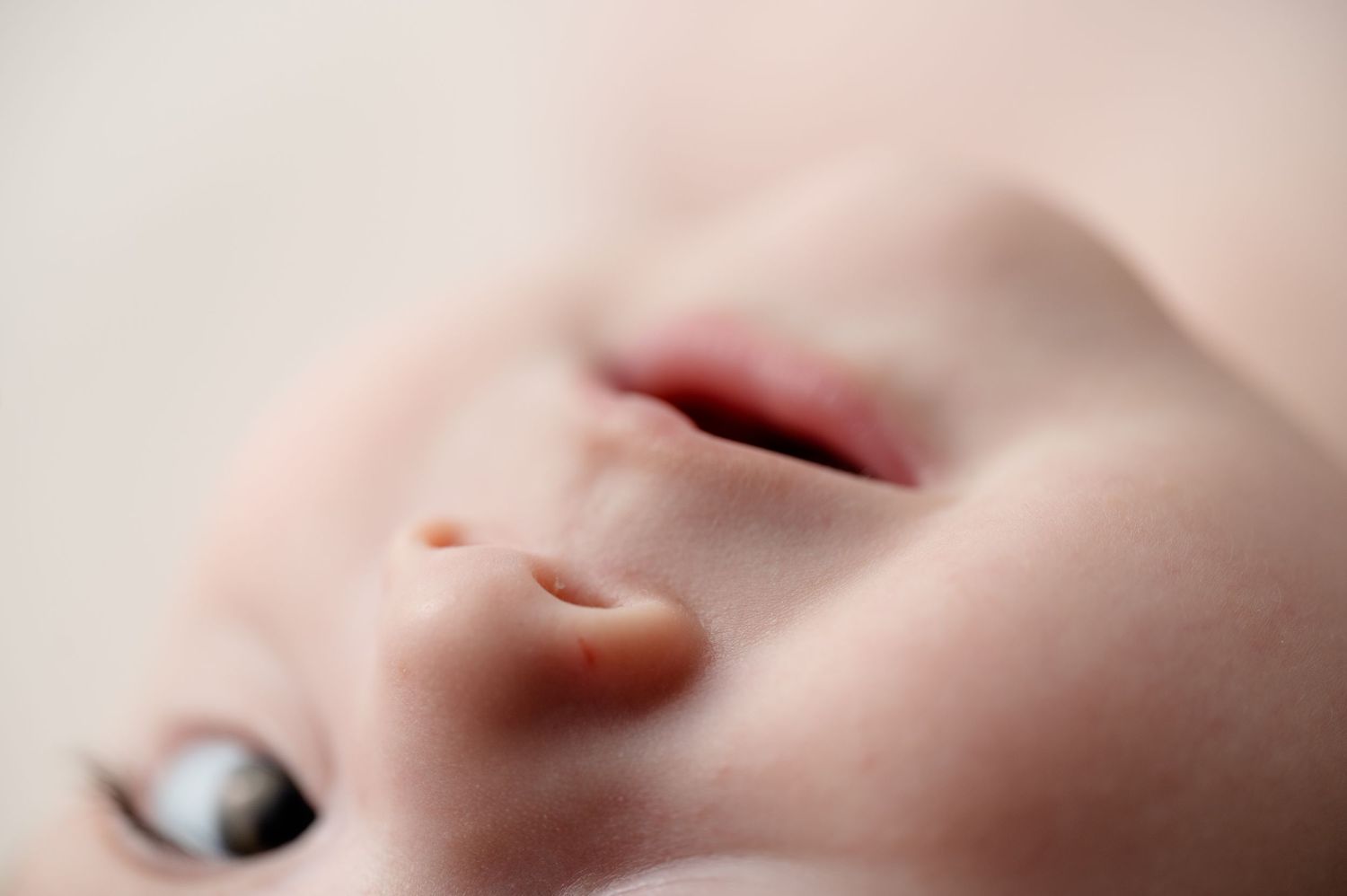 Extreme close-up of an infant's nose and mouth showing soft skin texture.