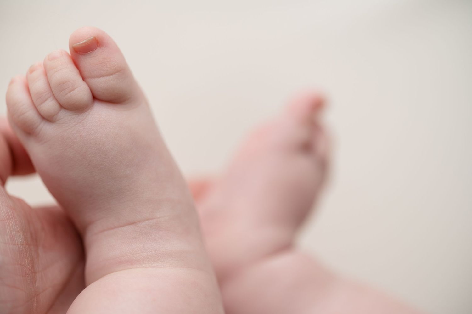 Detailed close-up photograph of a baby's tiny toes and feet.