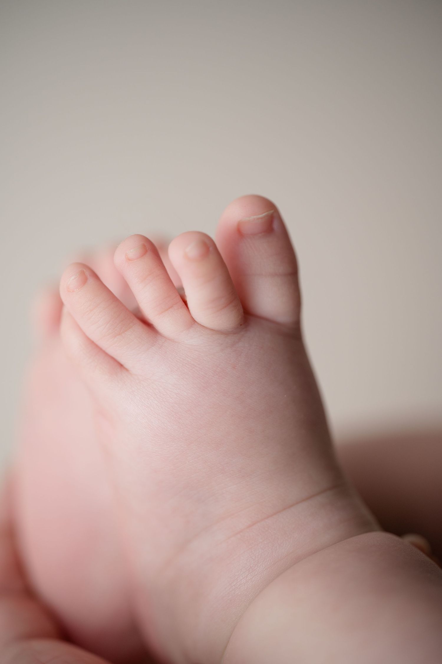 Detailed macro photography of a newborn's tiny toes and foot.