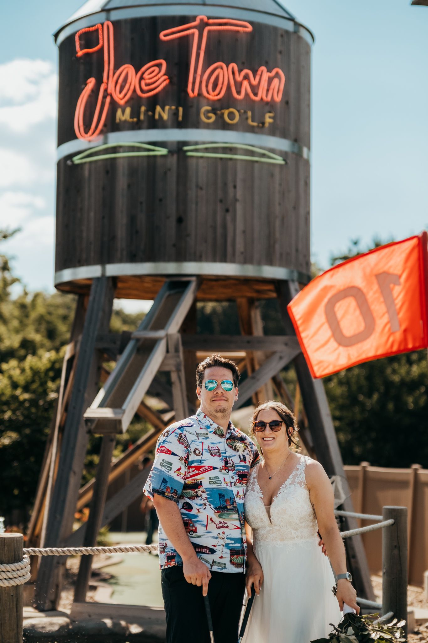A couple poses together in sunglasses and wedding attire at golf course in St. Joseph, Missouri.