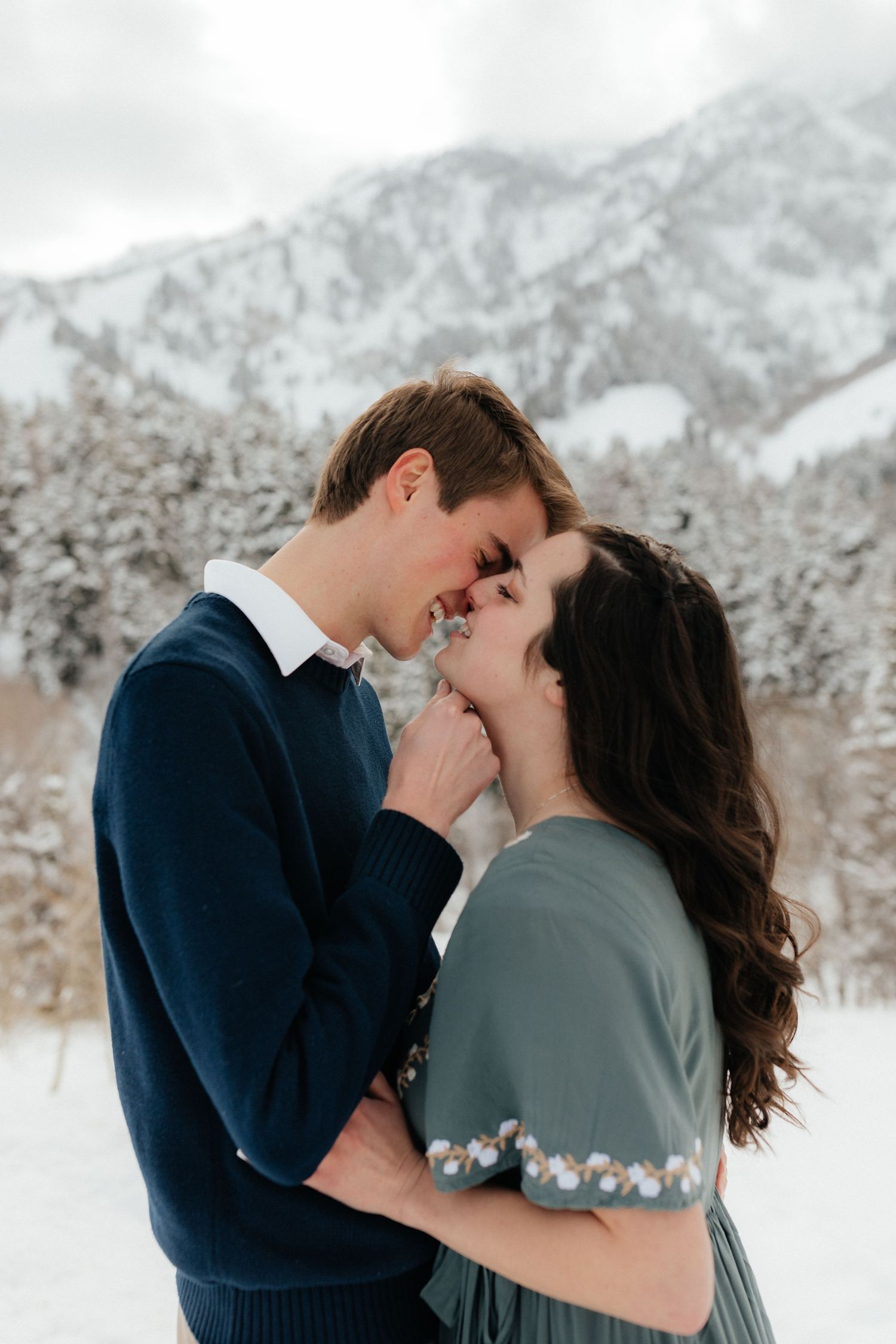 Engaged Couple about to kiss in Snow Mountains