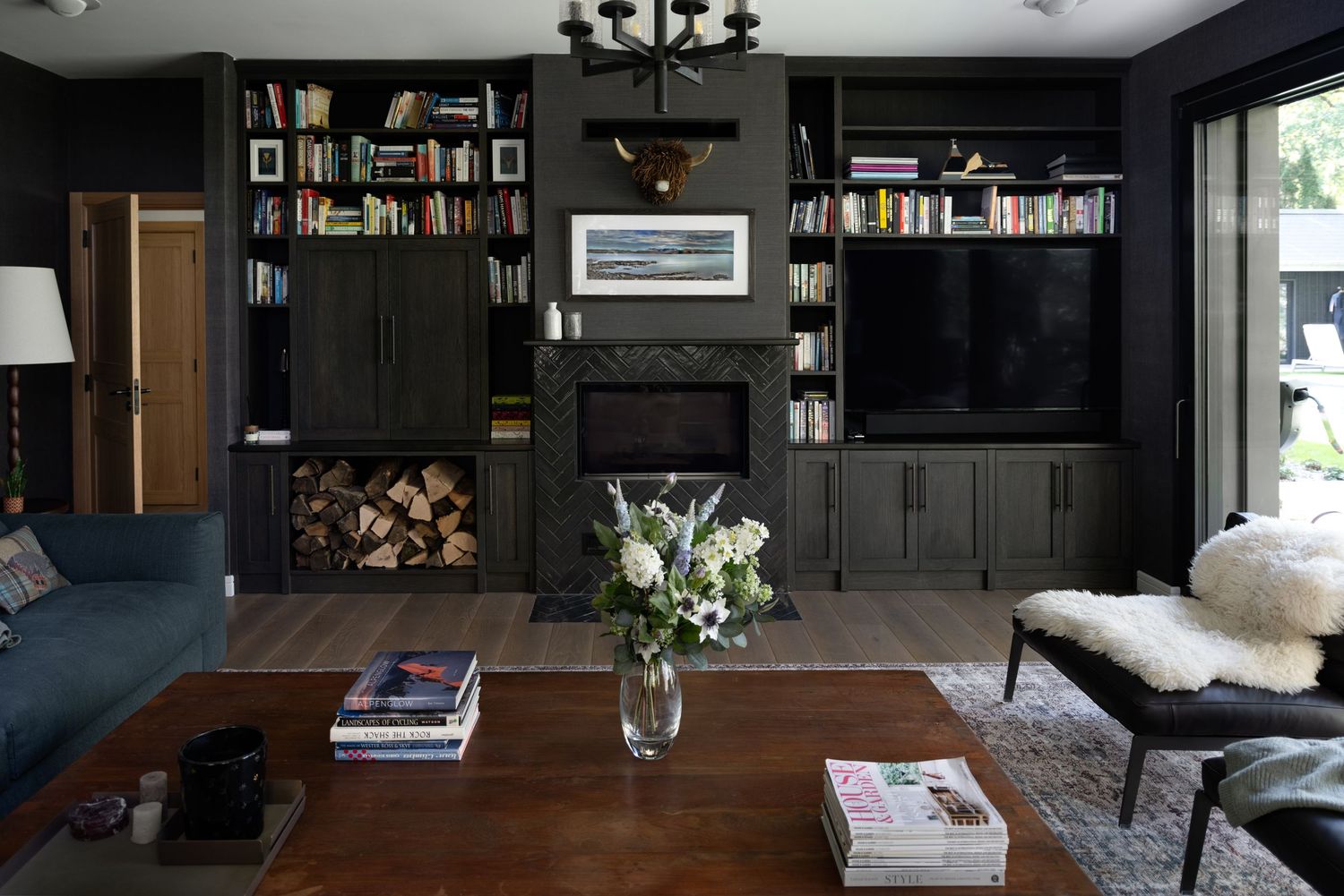 TV room in dark green with book shelves and a fireplace