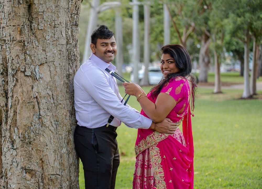 indian couple leaning against a tree in a park