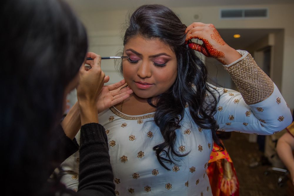 Indian bride getting makeup before wedding