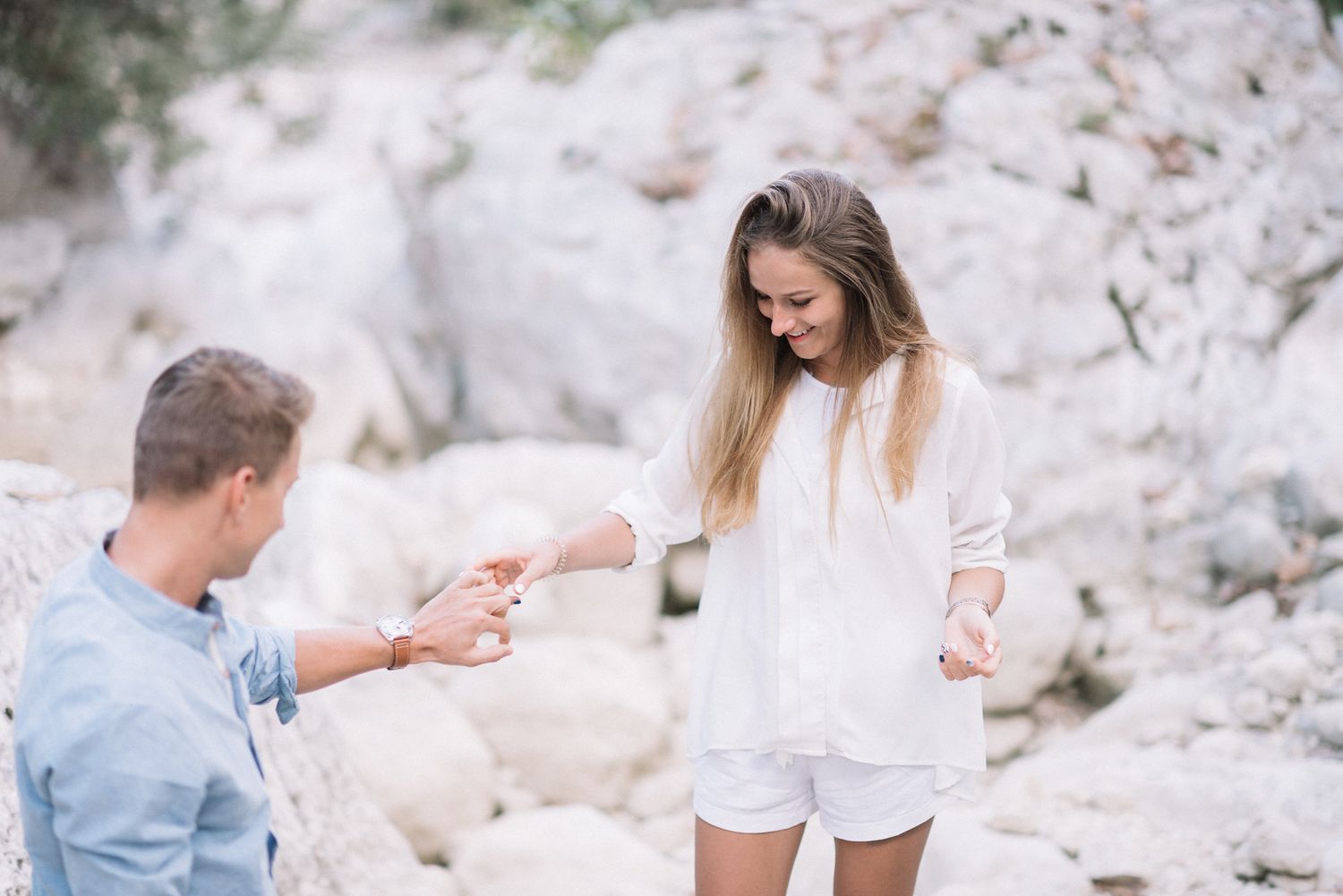 A couple sharing a special moment among white rocky cliffs.