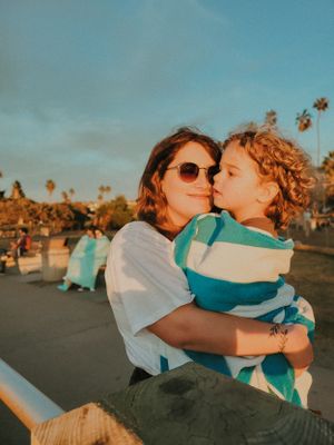 Couple sharing an intimate moment at sunset with palm trees in the background.