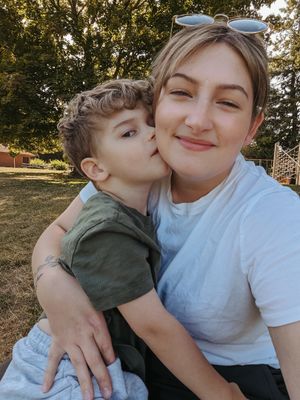 Sweet moment captured between parent and child outdoors in natural sunlight.