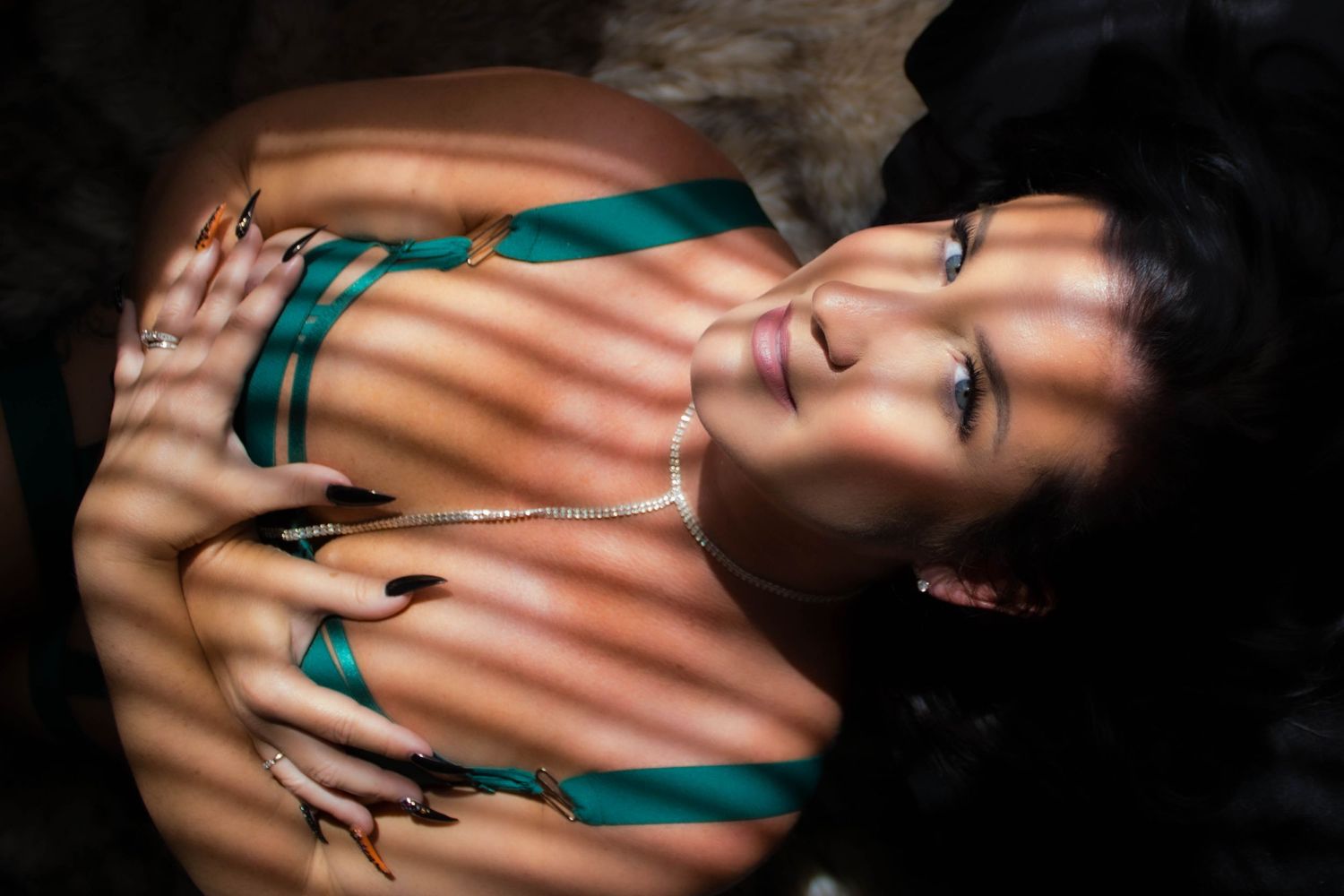 Creative portrait with venetian blind shadows creating dramatic lines and contrast.