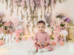 Romantic garden themed birthday setup with hanging floral arrangements and pink decor.