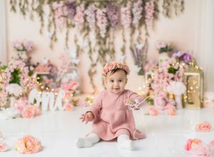 Floral garden themed birthday setup with hanging wisteria and pink decorations.