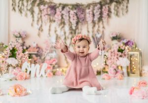 Enchanted garden birthday scene with cascading flowers and soft pink accents.